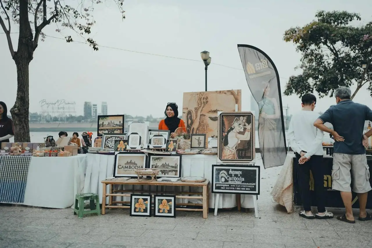 A vibrant street market along the riverside in Phnom Penh, showcasing Cambodian art and crafts.