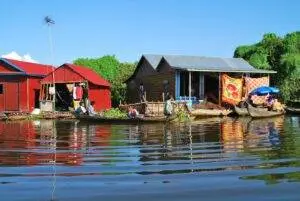 Vibrant floating village scene with locals in wooden boats on a sunny day.