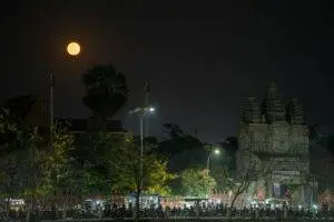 A serene night view of a temple in Battambang, Cambodia, under a full moon.