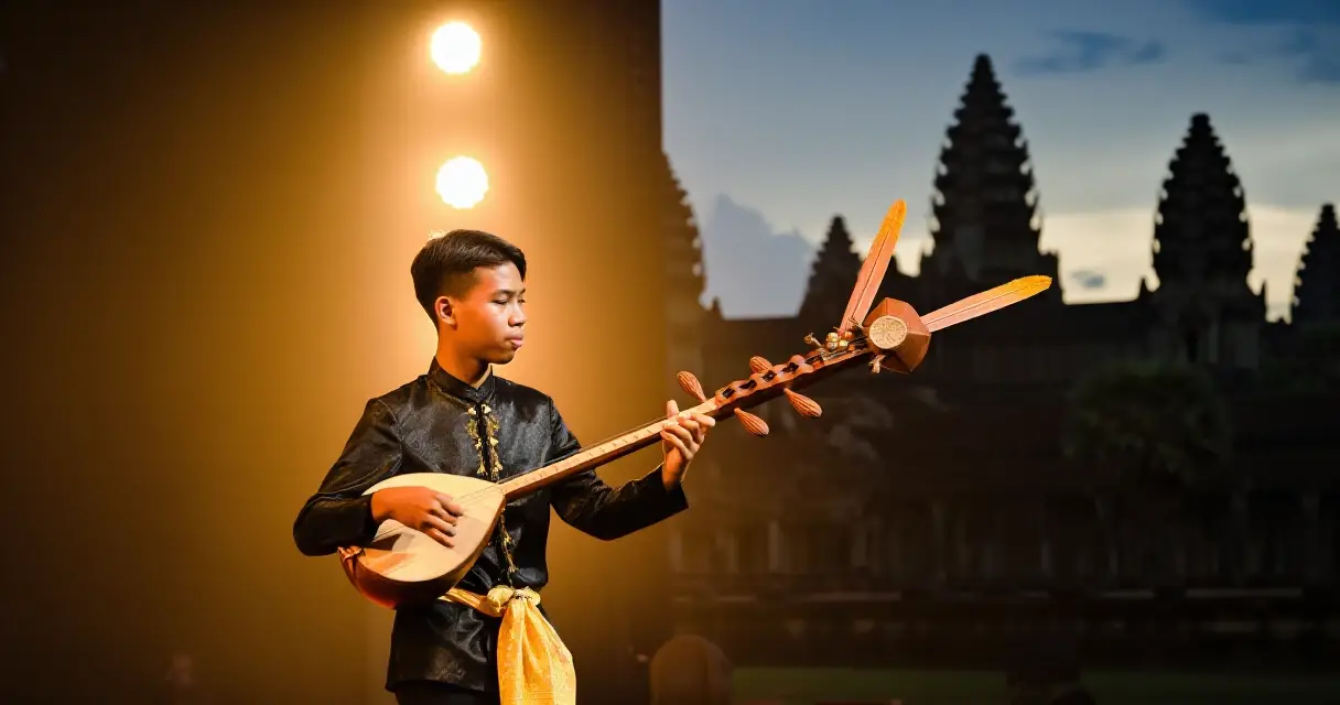 សិល្បករកំពុងលេងចាប៉ីដងវែងលើឆាកតន្ត្រីខ្មែរ